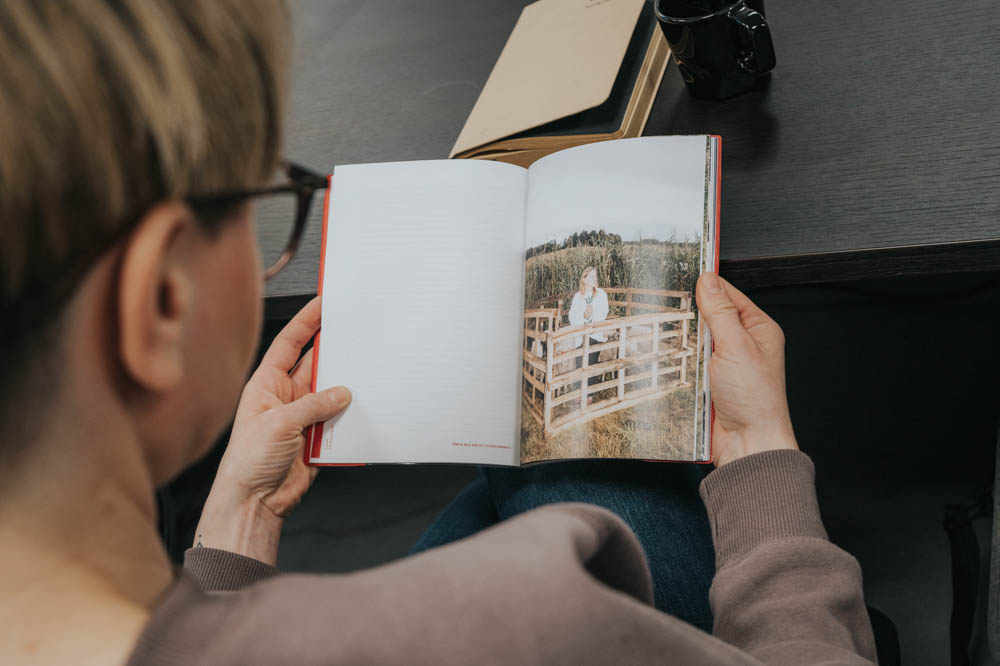 Zdjęcie przedstawia osobę oglądającą fotografię. Kadr z góry.