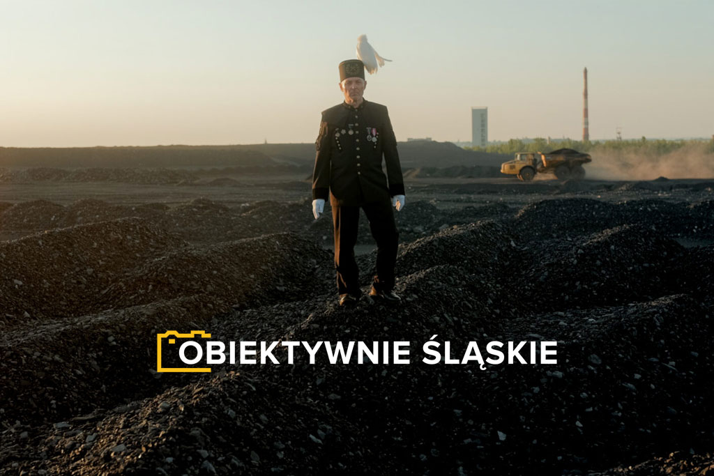 Górnik w mundurze galowym stoi na hałdzie na tle kopalni. Na dole logotyp konkursu.